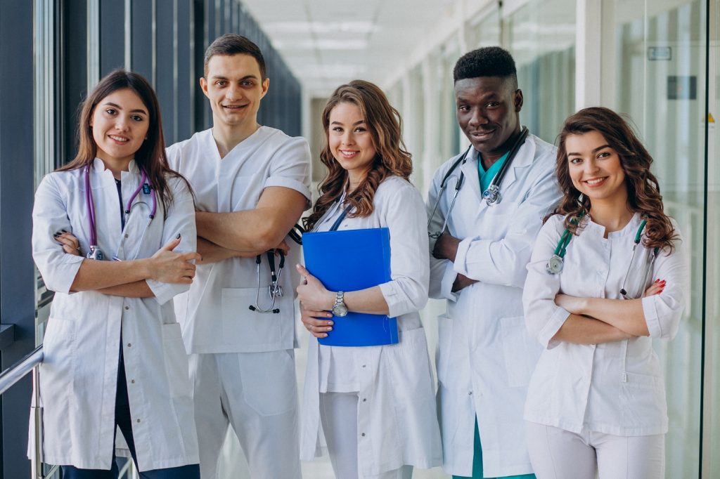 team-of-young-specialist-doctors-standing-in-the-corridor-of-the-hospital
